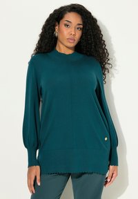 Teal gestrickter Pullover mit hohem Kragen, gewelltem Saum und Ballonärmeln; besitzt einen goldenen Akzentknopf an der Seite. Sanfte Textur.