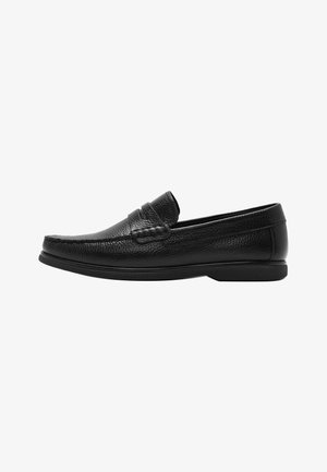 Mocassin pour homme en cuir noir avec surface texturée, style à enfiler, détails cousus et semelle en caoutchouc basse, présenté de profil.
