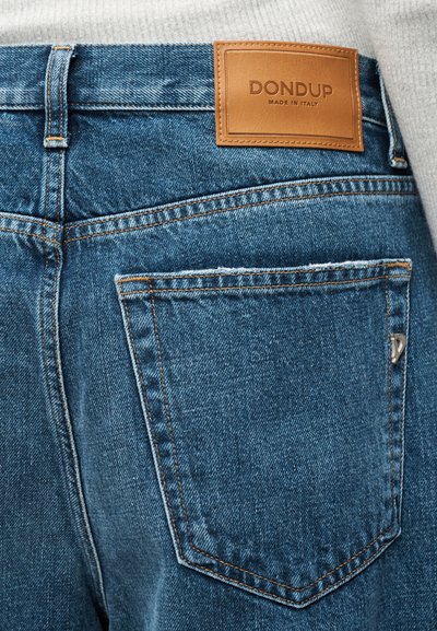 Πίσω τσέπη μπλε τζιν τζιν με καφέ δερμάτινο ταμπελάκι με την επιγραφή «DONDUP Made in Italy» ραμμένη στη μέση.