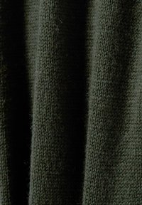 Dzianina w ciemnozielonym kolorze, ukazująca teksturowany wzór. Materiał ma miękki wygląd z widocznymi włóknami i delikatnym połyskiem.