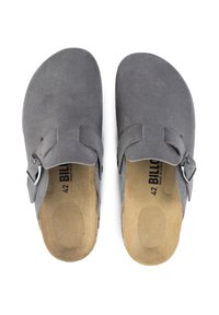 Sabots en daim gris avec une semelle plate, une boucle en argent ajustable et une semelle intérieure de couleur naturelle. Taille marquée 42. Design simple et ouvert à l'arrière.