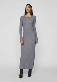 Gray ribbed knit maxi dress with long sleeves and a crew neckline, paired with sleek black heeled boots. Smooth texture, fitted silhouette.