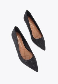 Ballerine nere a punta con una superficie testurizzata ricoperta di piccole strass. La fodera interna liscia presenta un design trapuntato.