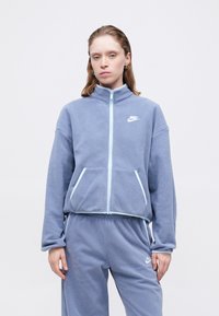 Nike zip-up bunda z jemného šedého fleecu s svetlomodrými akcentmi, s vysokým golierom a dvoma prednými vreckami.
