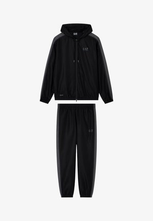 Giacca nera con cappuccio e zip e pantaloni neri abbinati con vita elastica, strisce laterali grigio scuro e loghi EA7 sul petto e sulla coscia.