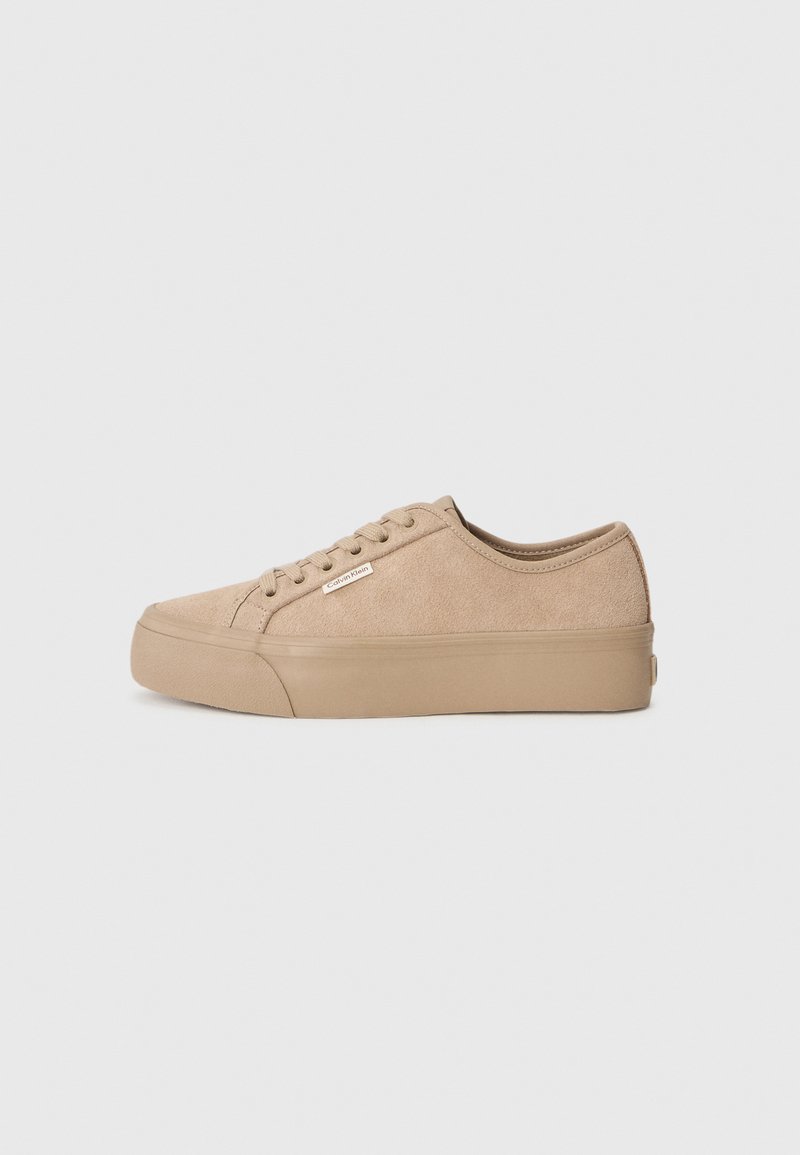 Beige suede low-top sneakers with a flat rubber sole, featuring a rounded toe and minimal branding on the side.