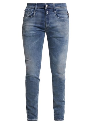 Jeans denim slim fit in azzurro chiaro, con cinque tasche, chiusura a bottoni e zip, con una leggera scoloritura e una texture liscia.
