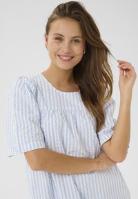 Svetlo modra in bela črtasta kratkosleečna majica s krožnim izrezom in nabranim pasom, izdelana iz mehke, teksturirane tkanine.