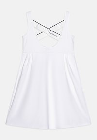 Vestido blanco tipo A con escote redondo, tirantes anchos y detalle de cruzado en la espalda. Hecho de una tela suave y elástica.