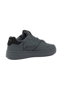 Hall-hall sneaker, mille hallid, ümar nina, nööbidisain ja reljeefne logo välisküljel.