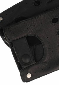 Guantes de cuero negro con diseño perforado, cierres a presión y textura suave. Forro interior visible a través de las secciones recortadas.