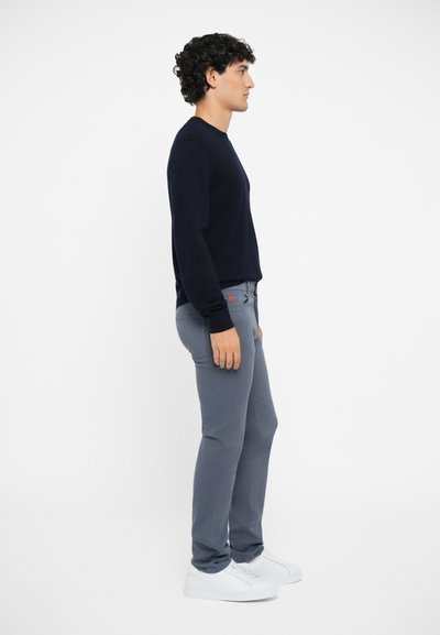 Navy sweater, gray pants, and white sneakers. Simple design, fitted shape, smooth texture. Subtle logo detail on pants.