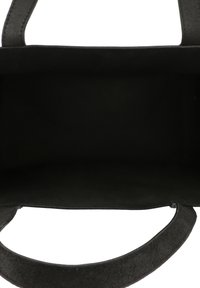 Svart läder tote-väska med texturerad yta, öppen top och plana handtag. Inuti är den svart med en slät, matt yta. Ingen synlig hårdvara.