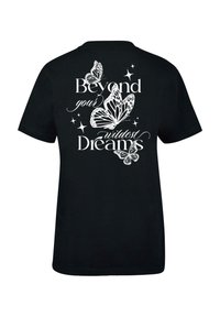 Black cotton T-shirt featuring white text “Beyond your wildest Dreams” with detailed butterfly graphics and star accents on the back.