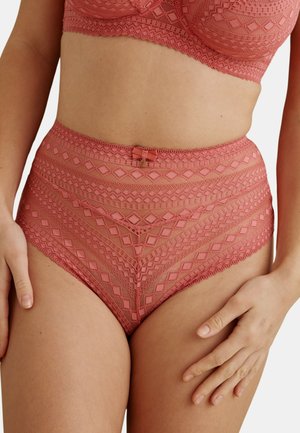 Culotte taille haute en dentelle et soutien-gorge assorti en rose poudré avec des motifs géométriques et un petit nœud au centre devant.