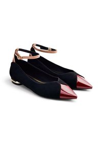 Ballerines en suède noir avec un bout pointu en cuir verni rouge. Présentent des brides de cheville et un petit talon métallique. Texture lisse avec un design minimal.