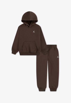 Brauner Baumwoll-Hoodie mit einer Fronttasche und weißem Logo, kombiniert mit passenden Jogginghosen, die einen elastischen Bund und Bündchen haben.