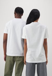 Calvin Klein Jeans LOGO REPEAT - Camiseta estampada - bright white