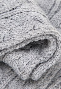 Grijze gebreide stof met een dik, gestructureerd patroon van verweven draden, opgerold om de zachtheid en warmte te tonen.