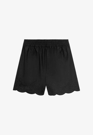 Svart shorts med elastisk midja. Har broderade blommönster längs den vågiga fållen och en slät, strukturerad yta.