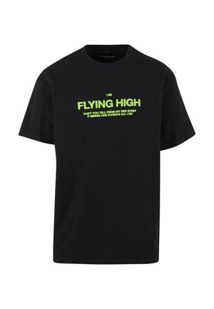 Sort bomulds T-shirt med korte ærmer, der har fed, fluorescerende grøn tekst: "I BE FLYING HIGH" og yderligere lille tekst nedenfor.