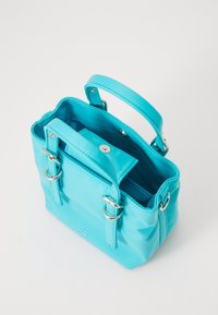 Borsa in pelle turchese con due manici, hardware metallico, chiusura a bottone singolo e un ampio interno con una tasca aggiuntiva.