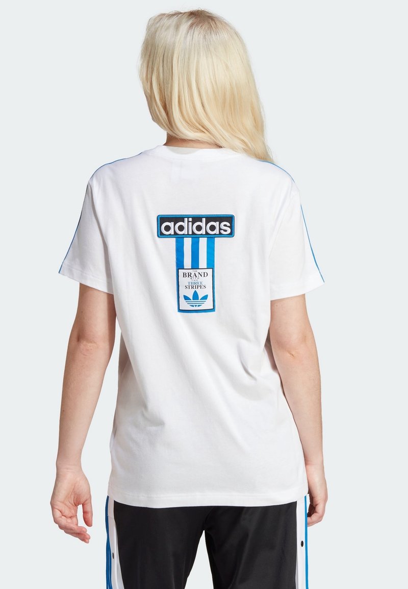 Vit bomullströja med svart och blå Adidas-logotyp och grafik på baksidan, med blå accentlinjer längs axelsömmarna.