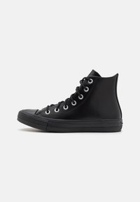 Schwarze High-Top-Sneaker aus glattem Leder mit weißen Metallösen, einer runden Zehenkappe und einer strukturierten Gummisohle.