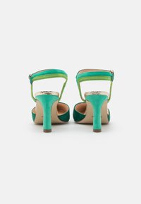 Zelené a tyrkysové dvoubarevné sandály na vysokém podpatku s metalickým zlatým akcentem. Disponují elegantním designem, páskem kolem kotníku a texturovanou látkou.