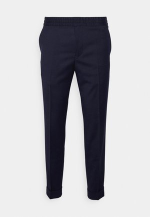 Pantalones azul marino con textura suave, presentan una cintura elástica y dobladillos enrollados, diseñados en un corte ajustado con bolsillos laterales.