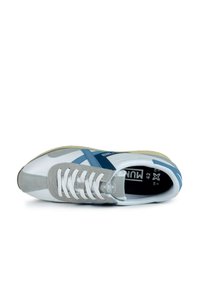 Zapatillas blancas y grises con acentos azules. Presentan materiales de cuero suave y ante, forma de puntera redonda y cierre de cordones en la parte delantera.