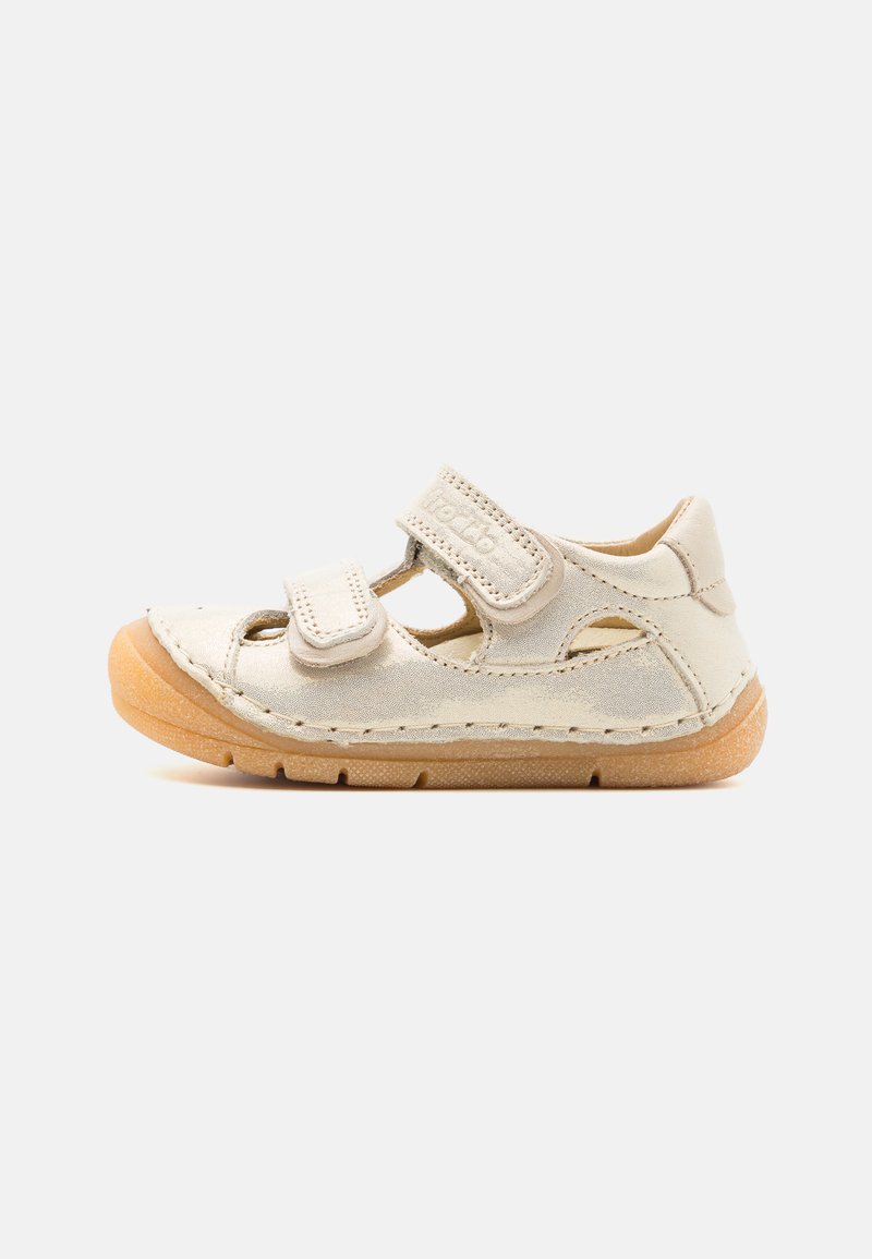 Lys beige sandal med to borrelåsrader, åpne sider, teksturert semsket skinn på overdelen, og en brun gummisåle med sømdetaljer.