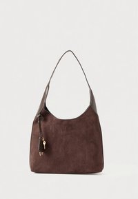 Sac bandoulière en daim marron avec une sangle en cuir lisse, une forme arrondie et un fermoir doré orné d'un détail à pampille décorative.