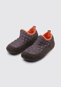Zapatillas acolchadas de color gris oscuro con un forro interior naranja, exterior de textura suave y diseño redondeado, que cuentan con una pestaña en la parte posterior.