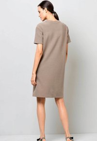 Helles braunes, kurzes Kleid mit kurzen Ärmeln und knielanger Länge, mit einem schlichten Design und geradem Schnitt, hergestellt aus weichem, strukturiertem Stoff.