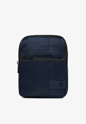 Kompakte, marineblaue Umhängetasche mit vorderer Reißverschlusstasche, schwarzem Besatz und kleinem geprägtem Logo in der unteren rechten Ecke.