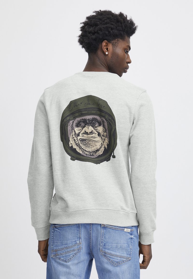 Lichtgrijze sweatshirt met een grafisch ontwerp van een gorilla in een ruimtehelm op de achterkant. Heeft ribgebreide manchetten en een ronde hals.