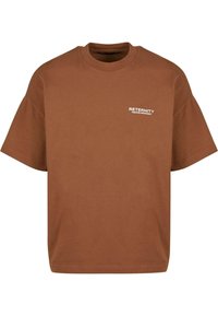 Brun bomulds t-shirt med kortærmer, rund halsudskæring og et hvidt logo "RETERNITY CREATIVE DEPARTMENT" på forsiden.
