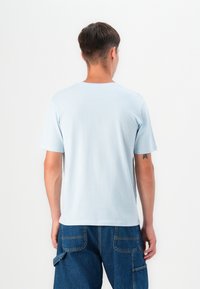 Light blue cotton t-shirt with short sleeves. Classic crew neckline, soft texture, and a relaxed fit. Back view showing smooth finish.