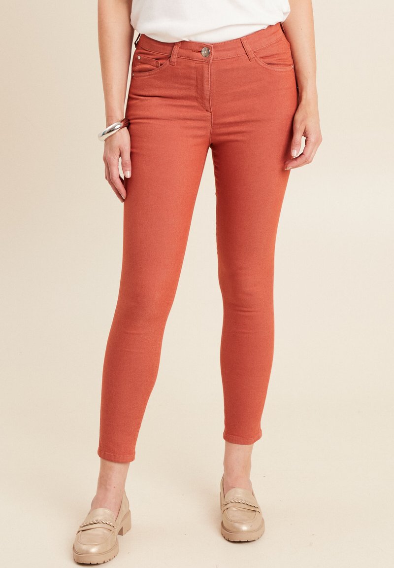 Roestkleurige skinny jeans van een rekbare katoenmix, voorzien van vijf zakken en een metalen knoopsluiting. Gladde textuur met een strak aansluitend ontwerp.