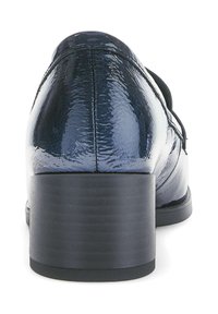 Zapato de charol azul marino con un tacón bajo y texturizado negro, que presenta una superficie lisa y un diseño minimalista. Vista desde atrás.