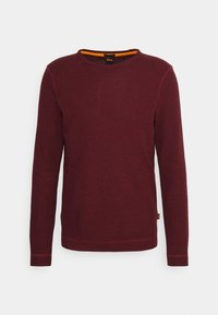 Bordowa koszulka z długim rękawem wykonana z miękkiej tkaniny, z okrągłym dekoltem i kontrastującą pomarańczową podszewką przy szyi, z delikatnie przeszytymi krawędziami.