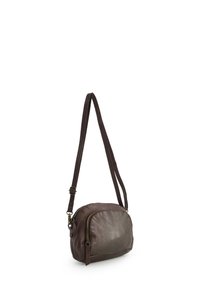 Hnědá kožená crossbody taška s zaobleným tvarem, vybavená zipovým uzávěrem, nastavitelným popruhem a jemnými texturovými variacemi.