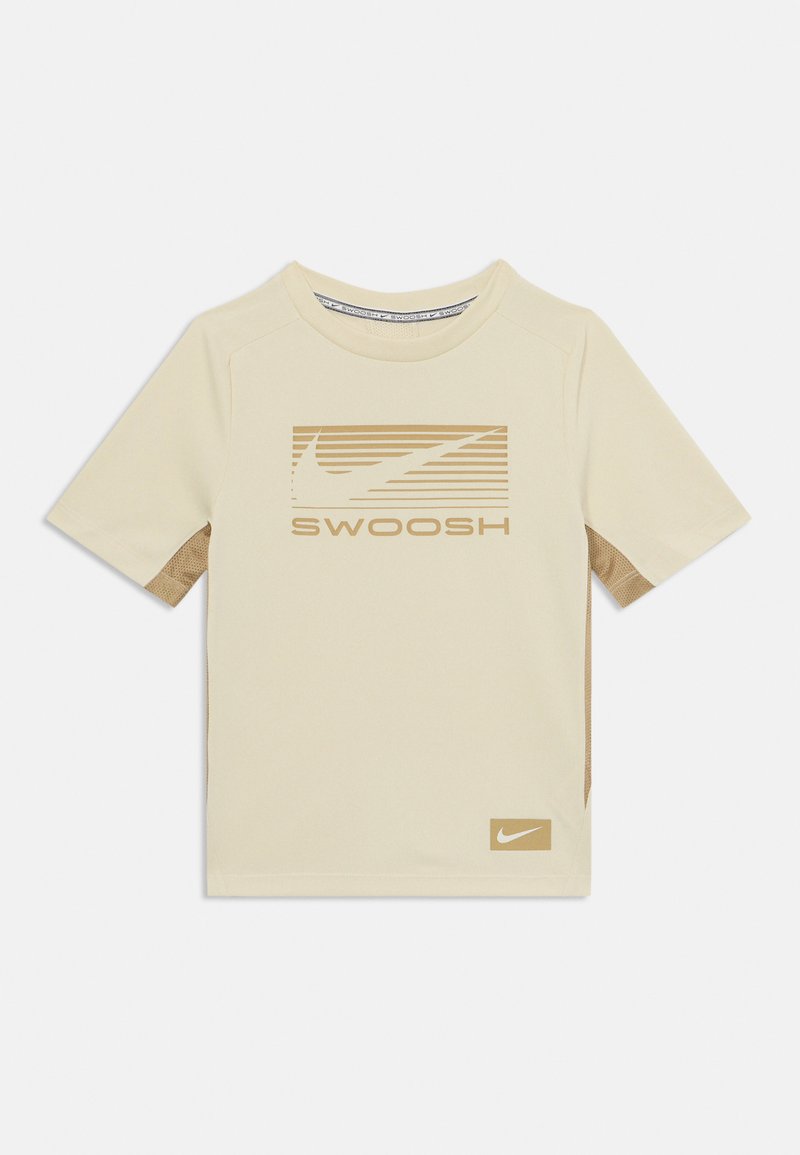 Trumpas kremas marškinėliai su trumpomis rankovėmis, turintys tekstūruotą smėlio spalvos skyrių, rudą juostuotą "Swoosh" logotipą ir mažą smėlio spalvos Nike logotipą ant apatinio krašto.