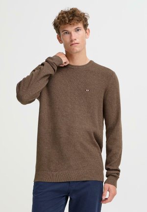 Brązowy sweter dzianinowy o teksturowanym wykończeniu, okrągłym dekolcie i długich rękawach. Posiada małe, wielokolorowe logo na lewej piersi.