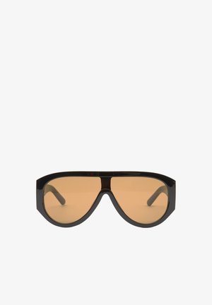 Czarne oversize okulary przeciwsłoneczne z brązowymi soczewkami, z szerokimi, kątowymi oprawkami i prostymi ramionami. Gładkie, błyszczące wykończenie, minimalna liczba elementów.
