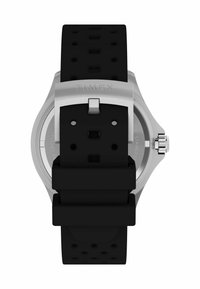 Montre Timex avec un bracelet en caoutchouc noir, un boîtier en acier inoxydable et un dos texturé avec plusieurs trous de réglage et une boucle en argent.