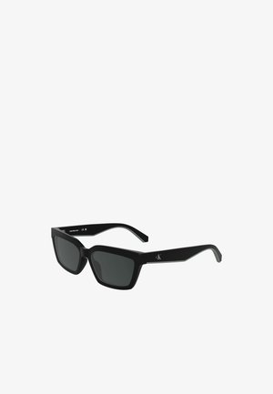 Schwarze rechteckige Sonnenbrille mit dunklen Gläsern, matte Oberfläche und dezentem Logo-Detail an den Bügeln. Leichter Rahmen aus Kunststoff.