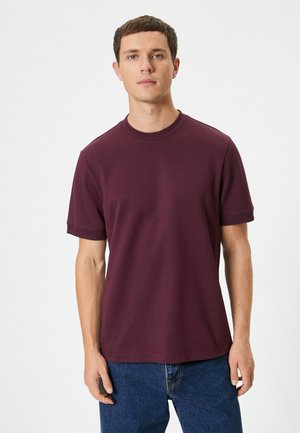 Burgunderfarbene Kurzarm-T-Shirt in entspannter Passform, hergestellt aus einem glatten Baumwollmix mit Rundhalsausschnitt und gerippten Bündchen für zusätzliche Textur.