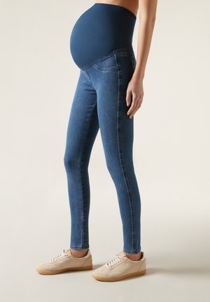 Mammabyxor i mörkblå denim med hög, elastisk midjeband; figurnära design med subtila sömmar och sidofickor.